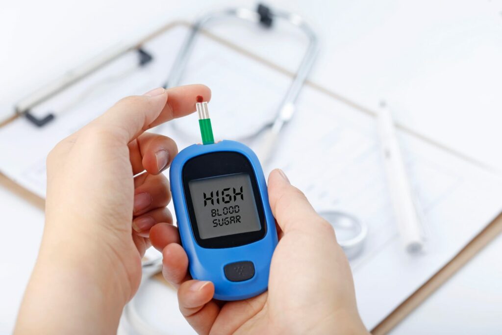 A person measuring their blood sugar with a blood sugar monitoring device.